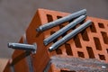 Set of parts for mounting anchors in hollow brick and concrete lie on the surface of the brickwork in any order. Threaded studs Royalty Free Stock Photo