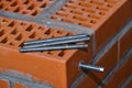 Set of parts for mounting anchors in hollow brick and concrete lie on the surface of the brickwork in any order. Threaded studs Royalty Free Stock Photo