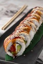 Set of philadelphia rolls with eel, smoked salmon, avocado and green bamboo leaf in a black ceramic plate with chopstick on a Royalty Free Stock Photo