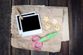 Set of photo frame scissors and crumpled paper on wooden background