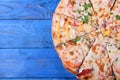 Set of pieces of different kinds of pizza on blue table. Copy space