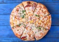 Set of pieces of different kinds of pizza on blue table