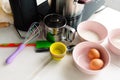 Set of pink bowls with raw ingredients for baking. A set of tools for making dough. Whisk and baking molds.