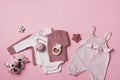 Set of pink clothes and accessories fot newborn girl. Toys, bodysuit, romper, knitted cardigan, shoes, bib on pastel Royalty Free Stock Photo