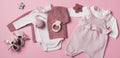 Set of pink clothes and accessories fot newborn girl. Toys, bodysuit, romper, knitted cardigan, shoes, bib on pastel Royalty Free Stock Photo