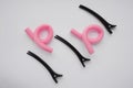 Set pink hair curlers and black hairpins isolated on white background Royalty Free Stock Photo