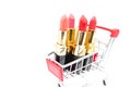 Set pink  lipstick in shopping cart on white background Royalty Free Stock Photo