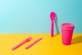 Set of pink plastic fork, knife and spoon, and paper coffee cup Royalty Free Stock Photo
