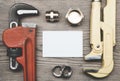 Set of pipes plumbing tools fittings and business card on the wooden background Royalty Free Stock Photo