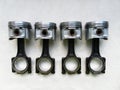 A set of pistons and rods for automobile engine on a background