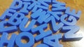 Set of plastic alphabet letters placed on a wooden floor Royalty Free Stock Photo