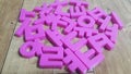 Set of plastic alphabet letters placed on a wooden floor Royalty Free Stock Photo