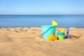 Set of plastic beach toys on sand near sea Royalty Free Stock Photo