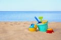 Set of plastic beach toys on sand near sea Royalty Free Stock Photo