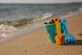 Set of plastic beach toys on sand near sea, space for text. Outdoor play Royalty Free Stock Photo