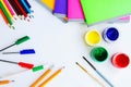 set of plastic cans with colored paints, brushes, pencils, pens and colored notebooks on white background. Royalty Free Stock Photo