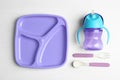 Set of plastic dishware on wooden table, flat lay. Serving baby food