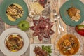 Set of plates of homemade food and jabugo ham with forks, hake with seafood, entrecote chopped with padron peppers, pork cheek