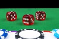 A set of poker chips stack on a green game table with a dice rolls. Black background. risk concept - playing poker in casino. Royalty Free Stock Photo