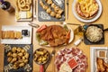 set of popular Spanish dishes. Roman squid, Galician octopus, rice with mushrooms, cachopo in the center, Iberian acorn ham cover