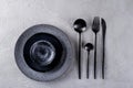 Set of porcelain handcraft grey and black plates and bowls cutlery set, linen napkin on a white wooden table. Royalty Free Stock Photo