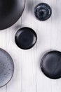 Set of porcelain handcraft grey and black plates and bowls on a white wooden table. Royalty Free Stock Photo