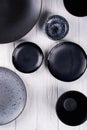 Set of porcelain handcraft grey and black plates and bowls on a white wooden table. Royalty Free Stock Photo