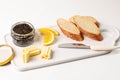 A set of premium black caviar, three pieces of white bread, butter on a serving platter.