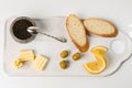 A set of premium black caviar, three pieces of white bread, butter on a serving platter.