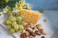 A set of products: grapes, different nuts on a wooden background, wooden old kitchen board Royalty Free Stock Photo