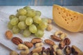 A set of products: grapes, different nuts on a wooden background, wooden old kitchen board Royalty Free Stock Photo