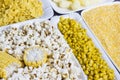 A set of products made from corn: popcorn, boiled grains, cereal, and corn grits. White plates Royalty Free Stock Photo