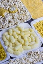 A set of products made from corn: popcorn, sticks, cereal, and corn grits. White plates Royalty Free Stock Photo