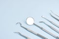 Set of professional dentist instruments on light blue background