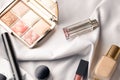 Set of professional elite decorative cosmetics for make-up on white silk cloth. Textile background. Copy space. Beauty and fashion Royalty Free Stock Photo