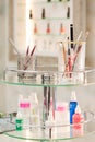 The set of professional make-up brushes and tools for manicure in glass containers on the glass table in beauty salon. Royalty Free Stock Photo