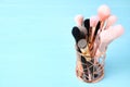 Set of professional makeup brushes in holder on blue wooden table. Space for text Royalty Free Stock Photo