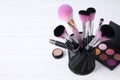 Set of professional makeup brushes in holder on wooden table. Space for text Royalty Free Stock Photo