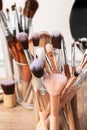 Set of professional makeup brushes and mirror on wooden table, closeup Royalty Free Stock Photo