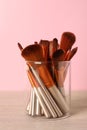 Set of professional makeup brushes on wooden table against pink background Royalty Free Stock Photo