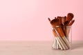 Set of professional makeup brushes on wooden table against pink background, space for text Royalty Free Stock Photo