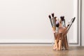 Set of professional makeup brushes on wooden table near white wall, space for text Royalty Free Stock Photo