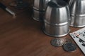 Set of professional tool to perform magic tricks on wooden table: three metal cups, some old coins, some playing cards and a magic