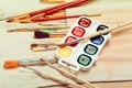 Set of professional watercolor artist brushes in a hand made roll case and watercolor paints close up Royalty Free Stock Photo