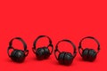 Set of protective black earphones muffs isolated on a red background