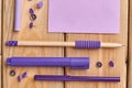 Set of purple stationery supplies on wooden table. Royalty Free Stock Photo
