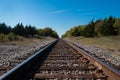 A set of railroad tracks disappearing on the distant horizon