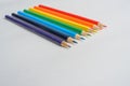 Set of rainbow colored pencils on blank piece of white paper, pointing towards viewer Royalty Free Stock Photo
