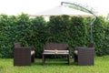 Set of rattan garden furniture under a big garden umbrella Royalty Free Stock Photo