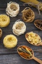 A set of raw pastas on spoons on a wooden table Royalty Free Stock Photo